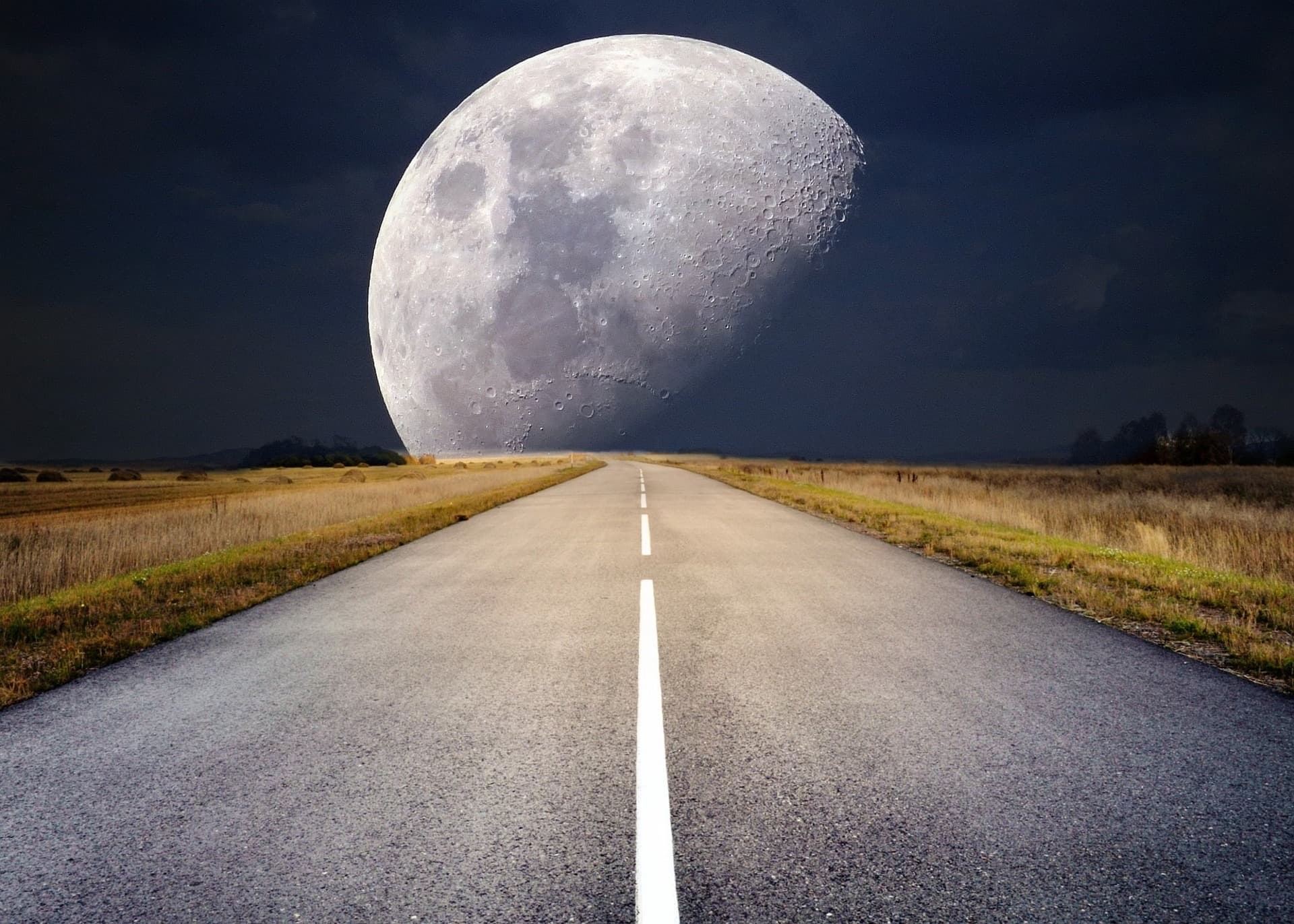 The Moon rising over a dark horizon, seen from Earth